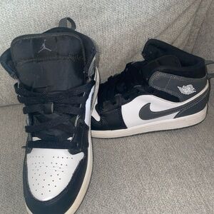 Nike Kids Air Jordan 1 Mid in the black, white, and iron grey colorway